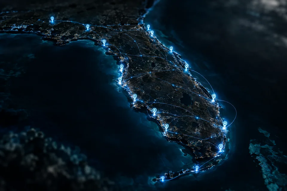 A dark map of the Florida coastline with glowing location pins marking MGD service locations